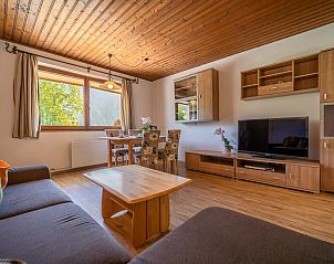 Gemtliches Wohnzimmer im Appartement Leonie, Schwendau, Tirol mit Holzinterieur und Blick in die Natur.