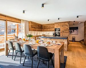 Gezellige eetruimte in Challet Teaga Kitzbuhel, Tirol, Oostenrijk met houten interieur en uitzicht op de bergen.