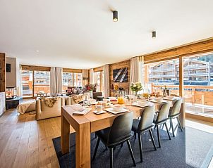 Gezellige woonkamer van Challet Teaga Kitzbuhel, Oostenrijk, met ruime eethoek en uitzicht op de bergen.