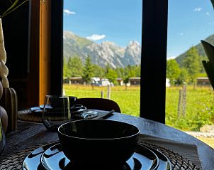 Enjoy the stunning mountain views from the dining area at Arlberg Cabin in Pettneu am Arlberg, Tyrol.