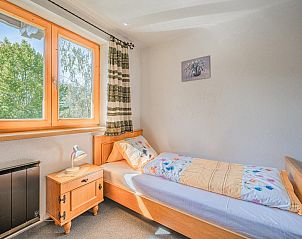 Cozy living room of Haus Leitner in Westendorf, Tyrol. Vacation home with wooden interior and views of the green surroundings.
