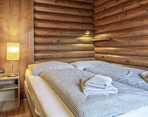 Gemtliches Schlafzimmer im Chalet Yosi im Brixental, Wrgl, Tirol, mit rustikalen Holzwnden und bequemen Betten.
