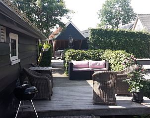 Zonnig terras bij 't Oppertje vakantiehuis in Terherne, met comfortabele zitplekken, nabij Sneekermeer.