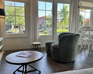 Gezellige woonkamer van De Koumelker vakantiehuis in Terherne, Sneekermeer, met uitzicht op de groene omgeving van de Friese meren.