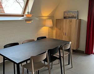 Gezellige eetruimte in Bungalow Sneekermeer, Goingarijp. Vakantiehuis met moderne inrichting en uitzicht op tuin nabij Friese meren.