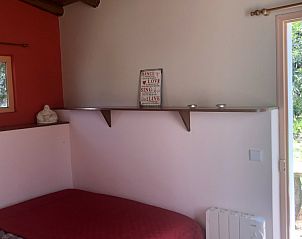 Sfeervolle slaapkamer in Monte Rosa - Huisje 3, Algarve, Portugal met rustieke elementen en uitzicht op de natuur.