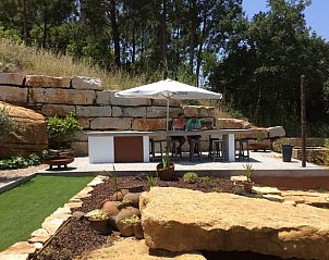 Enjoy the tranquility on the terrace of Holiday Home in Cela Velha, Vale do Tejo, Portugal, surrounded by nature and stone walls.