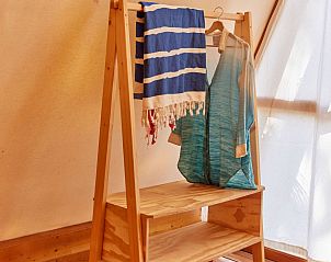 Interieur van Glamping Tipi Almadraba in Conil de la Frontera, Andalusi, met houten kledingrek in de lodge.