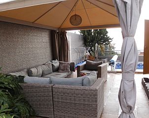 Ontspan op het gezellige terras van Casa Alex, een bed and breakfast in Adeje, Canarische Eilanden, met comfortabele zitplaatsen onder een schaduwrijke luifel.