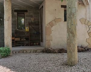 Ontspan op de rustieke veranda van Forest Edge, een vakantiehuis in Tivissa, Cataloni, omringd door de serene natuur van de Pyreneen.