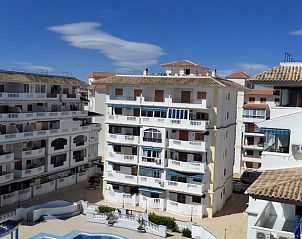 Uitzicht op Avenida Holanda appartement in La Mata, Costa Blanca, met helderblauwe lucht en zwembad.