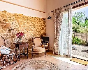 Gezellige woonkamer in Can Elisa - Appartement Oliva, Tarbena, Costa Blanca, Spanje met rustieke stenen muur en tuinzicht.