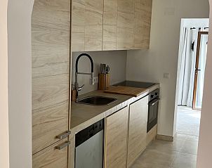 Moderne keuken in Casa Alegre Benissa, een vakantiehuis in Costa Blanca, Spanje, met stijlvolle houten afwerking en moderne apparatuur.