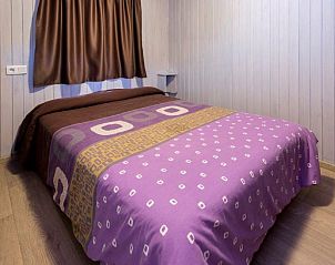 Sfeervolle slaapkamer in Camping Solmar - XALET, Blanes, Costa Brava, Spanje, met comfortabel bed en rustgevende houten wanden.