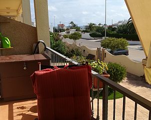 Ontspan op het zonnige balkon van appartement Majari in Vinars, Costa del Azahar, met uitzicht op de rustige straat en groene omgeving.