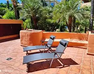 Ontspan op het zonnige terras van Jardines de Albaicn, een appartement in Benahavs, Costa del Sol, omringd door weelderige natuur.