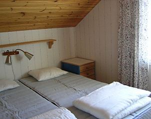 Gezellige slaapkamer in Cottage on an Island, Harstena, Gtaland, Zweden met houten plafond en knusse sfeer.