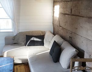 Cozy living room in Holiday Home in Torestorp, Gtaland, Sweden, with rustic wooden walls and comfortable sofa.