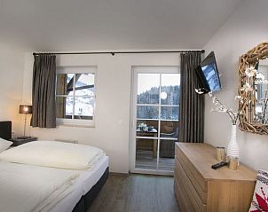 Gezellige slaapkamer in Stunning Alpin Apartment in Lenk, Berner Oberland, met uitzicht op de Zwitserse bergen.