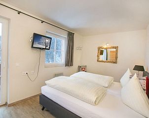 Sfeervolle slaapkamer in Stunning Alpin Apartment, Lenk im Simmental, omringd door de serene natuur van Berner Oberland, Zwitserland.