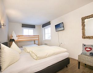 Gezellige slaapkamer in Stunning Alpin Apartment, Lenk im Simmental, Berner Oberland met een tweepersoonsbed en stapelbed.