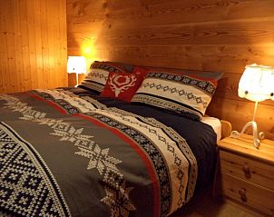 Gezellige slaapkamer in Chalet Ripzone in Belalp, Wallis, Zwitserland met houten interieur en sfeervolle verlichting.