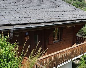 Huisje in Mrel-Filet, een charmant vakantiehuis in Wallis, Zwitserland, met een traditionele houten veranda en prachtig uitzicht op de natuur.