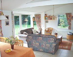 Gezellige woonkamer van schonevakantiebungalow in Exloo, Drenthe met uitzicht op de tuin.