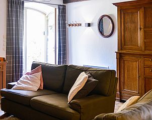 Gemtliches Wohnzimmer im Ferienhaus Point du Jour, Sapogne-sur-Marche, mit Holzofen und rustikalem Mobiliar.
