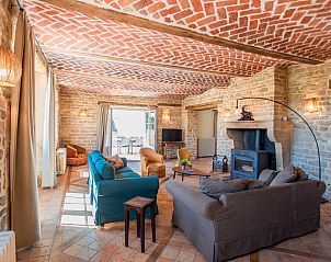 Gemtliches Wohnzimmer im Ferienhaus Gite du Moulin, Guignicourt-sur-Vence, Champagne Ardennes, mit rustikalen Steinwnden und Kamin.