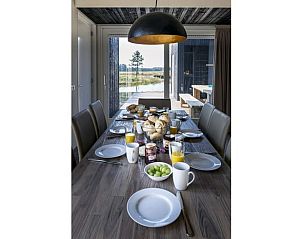 Gezellige eethoek in Huisje in Wapserveen met uitzicht op Drentse landschappen.