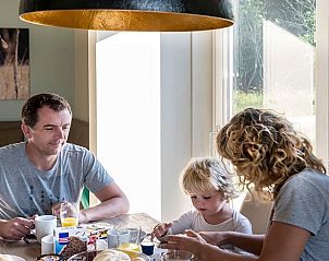 Gezin geniet van ontbijt in de eetkamer van Huisje in Wapserveen, Drenthe.