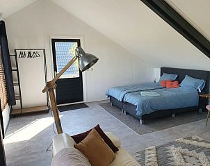 Stijlvolle binnenruimte met tweepersoonsbed in Vrijstaand landelijk appartement de Wijk, Drenthe.