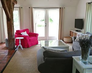 Lichte woonkamer met openslaande deuren in Vakantiehuisje in Wapse, prachtig uitzicht op tuin.