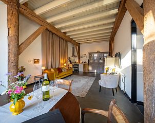 Ruime woonkamer in Huisje in Koekange, vakantieverblijf in Drenthe met houten balken en veel licht.