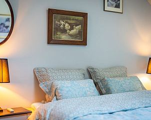 Sfeervolle slaapkamer in Huisje in Koekange, vakantieaccommodatie in Zuidwest Drenthe met kunst aan de muur.