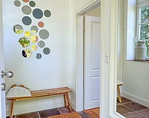 Entree van Huisje in Tetenbll, vakantiehuis in Tetenbll, Sleeswijk-Holstein met stijlvolle decoratie en houten bankje.