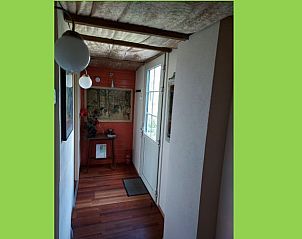 Gezellige gang in Vakantiehuis in Drachten, met houten vloer en kunstwerken, Friesland.