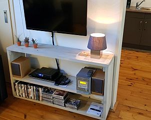 Entertainmenthoek met tv en boeken in Vakantiehuis in Drachten, Friese bossen.