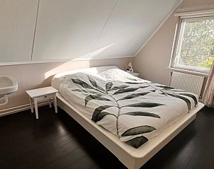 Slaapkamer met groot raam in Vakantiehuis in Nijemirdum, Friese bossen