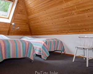 Mansardenzimmer mit zwei Betten im Ferienhaus in Ferwert, umgeben von der Ruhe Frieslands.