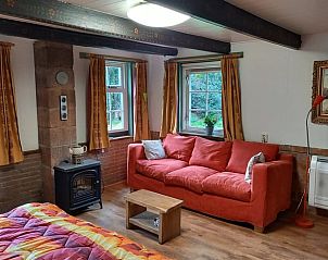 Lichte woonkamer in Vakantiehuis in Oldeholtpade met comfortabele bank.