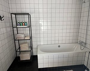 Stijlvolle badkamer met ligbad in Vakantiehuisje in Oldeholtpade, voor luxe ontspanning op het Friese platteland in Friesland.