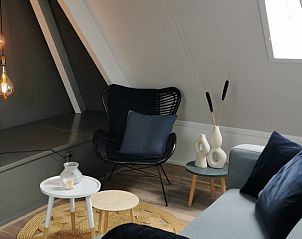 Stijlvolle zithoek in Huisje in Kootstertille, vakantiehuis op het Friese platteland, met moderne decoratie en sfeerverlichting.