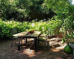 Lommerrijke tuin met zitgedeelte bij Vakantiehuis in Kootstertille, Friesland, voor een ontspannen verblijf.