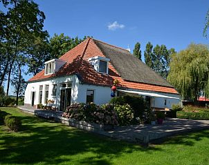 Vakantiehuis in Warten, gelegen op het Friese platteland in Friesland, met een groene tuin en traditionele architectuur.
