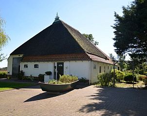 Charmant vakantiehuis in Warten op het Friese platteland, Friesland, omgeven door groene natuur en rustieke architectuur.