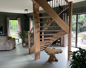 Open woonkamer in vakantiehuis in Spanga met houten trap en veel lichtinval.