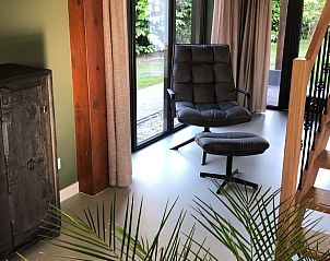 Gezellige leeshoek in vakantiehuis in Spanga met comfortabele stoel en uitzicht op de tuin.