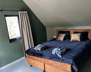 Gezellige slaapkamer in vakantiehuis in Spanga met comfortabel bed en rustgevende kleuren.
